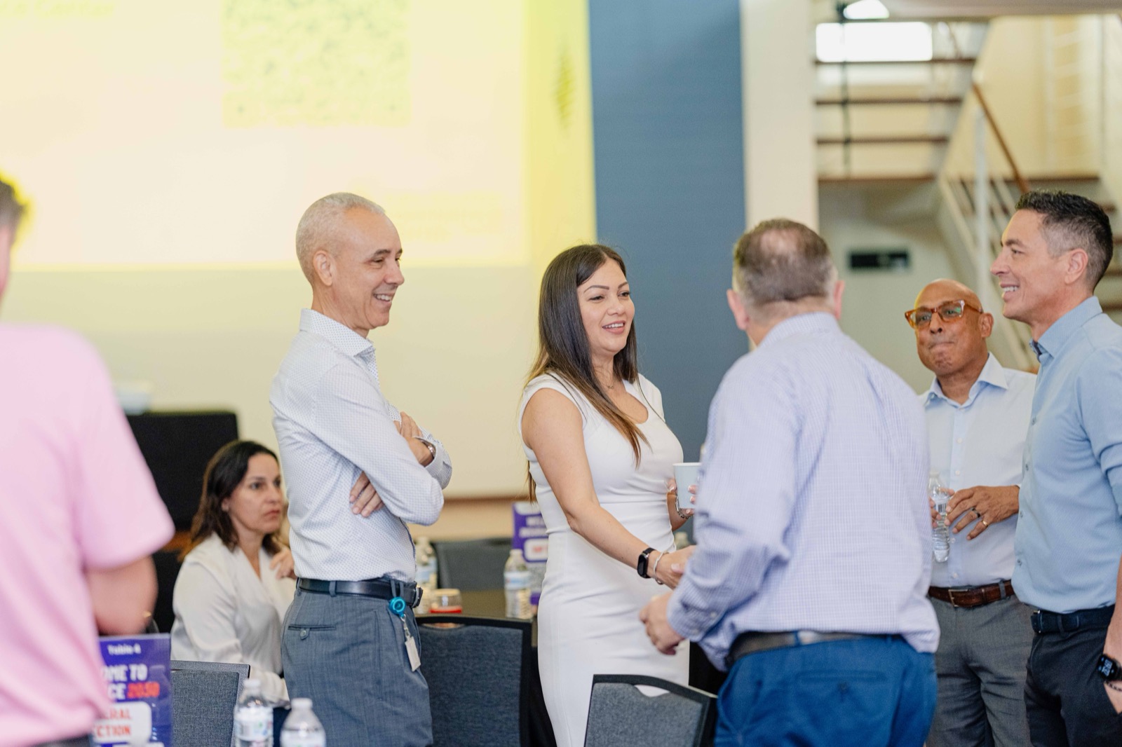 Networking session with presentation screen in background