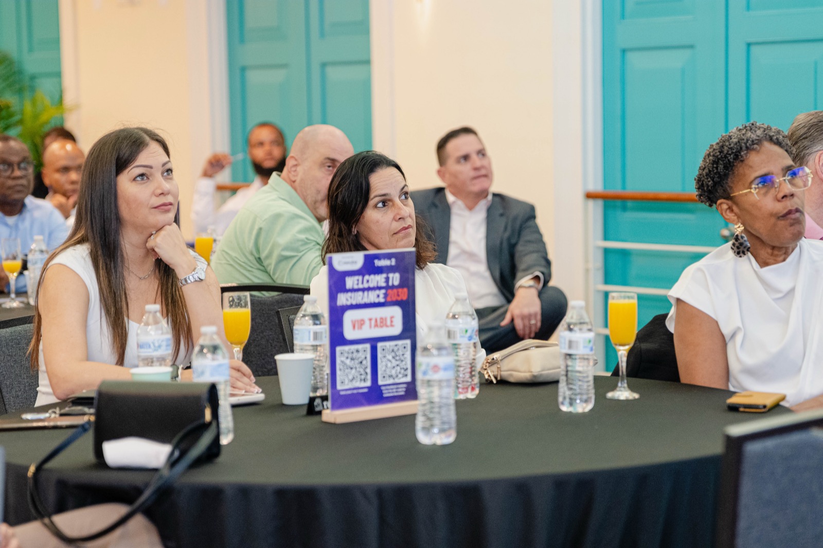 Audience seated at round tables with Insurance 2030 branding